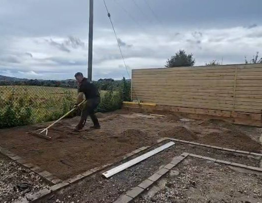 Maciek raking ground level on a garden rebuild in Wicklow